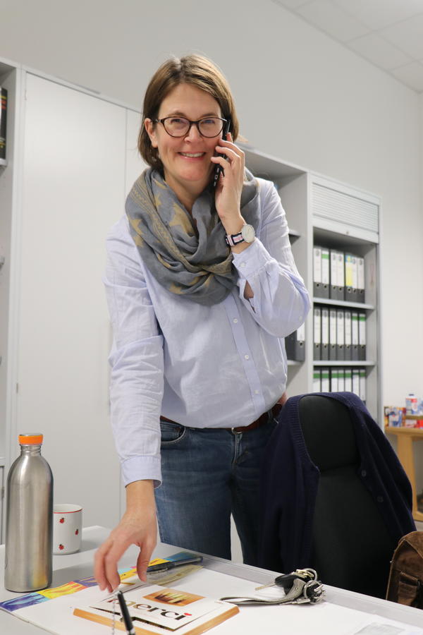 Die Leiterin der Musikschule Frau Türich stehend an ihrem Schreibtisch mit dem Telefonhöhrer in der Hand.